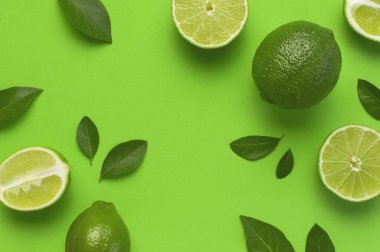 Taze sulu limon ve parlak yeşil arka planda yeşil yapraklar. Üst görünüm düz kopya alanı. Yaratıcı gıda geçmişi, tropikal meyve, C vitamini, narenciye. Bütünüyle kompozisyon ve limon dilimleri