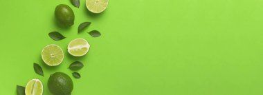 Taze sulu limon ve parlak yeşil arka planda yeşil yapraklar. Üst görünüm düz kopya alanı. Yaratıcı gıda geçmişi, tropikal meyve, C vitamini, narenciye. Bütünüyle kompozisyon ve limon dilimleri
