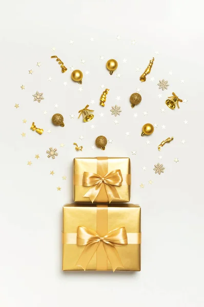 Feliz Navidad y Felices Fiestas tarjeta de felicitación. Hermosas bolas de regalo de oro cintas confeti estrellas sobre fondo gris vista superior plana laico. Año Nuevo presenta fiesta de decoraciones festivas 2020 celebración — Foto de Stock