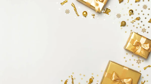 Vrolijk kerstfeest en gelukkige feestdagen wenskaart. Mooie gouden cadeau ballen linten confetti sterren op grijze achtergrond bovenaanzicht Platte lay. Nieuwjaar presenteert feestelijke decoraties partij 2020 viering — Stockfoto