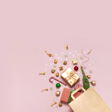 Yeni yıl Noel kompozisyonu. Kağıt torba ve Noel süslemeleri altın hediyeler Noel topları konfeti dalları konfetileri pembe zemin üzerinde Şeker Çubuğu düz görüş alanı üzerinde yatıyordu Kış 2020 Xmas