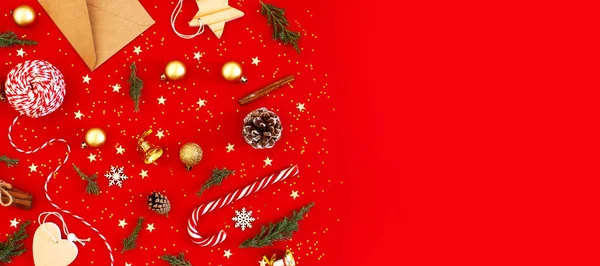 Újévi karácsonyi kompozíció. Ünnepi dekorációk arany karácsonyi labdák fenyő ágak konfetti hópelyhek harang piros háttérrel. Lapos feküdt felső nézet másolási hely. Téli újév 2020 Karácsonyi Ünnep — Stock Fotó