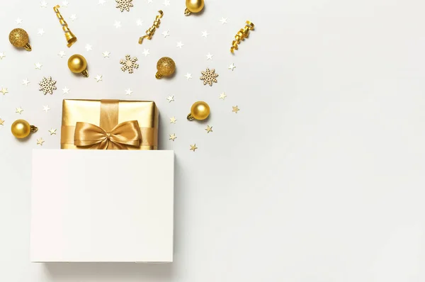 Schöne goldene Geschenk weiße Papiertüte Konfetti Sterne Weihnachtskugeln auf grauem Hintergrund Ansicht flach lag. Das neue Jahr präsentiert festliche Dekorationen. Frohe Weihnachten frohe Feiertage Karte — Stockfoto