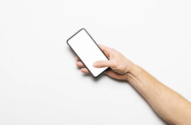 Erkek eller açık gri arka planda beyaz beyaz ekranlı modern bir siyah akıllı telefon tutuyor. Modern teknoloji, telefon, cihazlar, dokunmatik ekran, tasarımınız için şablon. Model