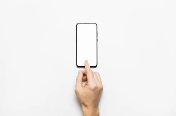 Mãos masculinas segurar um smartphone preto moderno com tela branca em branco no fundo cinza claro. Tecnologia moderna, telefone, gadget nas mãos, tela sensível ao toque, modelo para o seu design. Mockup — Fotografia de Stock