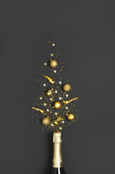 Fondo de Navidad y Año Nuevo. Botella de champán, bolas de navidad doradas, cintas festivas, confeti estrella sobre fondo negro vista superior. Tarjeta de vacaciones plana laico. Concepto de fiesta Decoraciones festivas 2020 — Foto de Stock