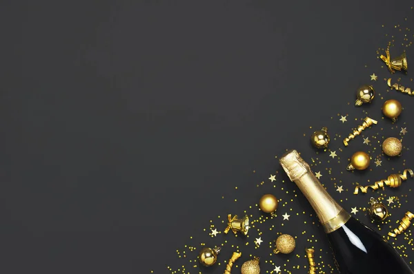 Natale e Capodanno sfondo. Bottiglia di champagne, palline di Natale dorate, nastri festivi, coriandoli stellati su sfondo nero vista dall'alto. Biglietto per vacanze flat lay. Concetto di festa Decorazioni festive 2020 — Foto Stock