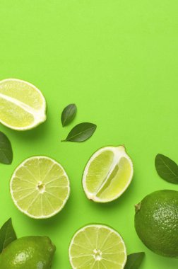 Taze sulu limon ve parlak yeşil arka planda yeşil yapraklar. Üst görünüm düz kopya alanı. Yaratıcı gıda geçmişi, tropikal meyve, C vitamini, narenciye. Bütünüyle kompozisyon ve limon dilimleri