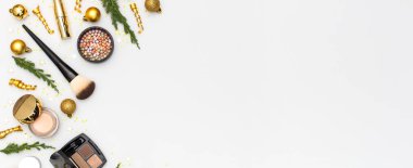 Makyaj maskarası vakfı krem ruj göz farı göz farı, yeni yıl süslemeleri altın noel topları konfeti yıldızları düz zemin üzerinde köknar dalları. Kozmetik, Noel Xmas