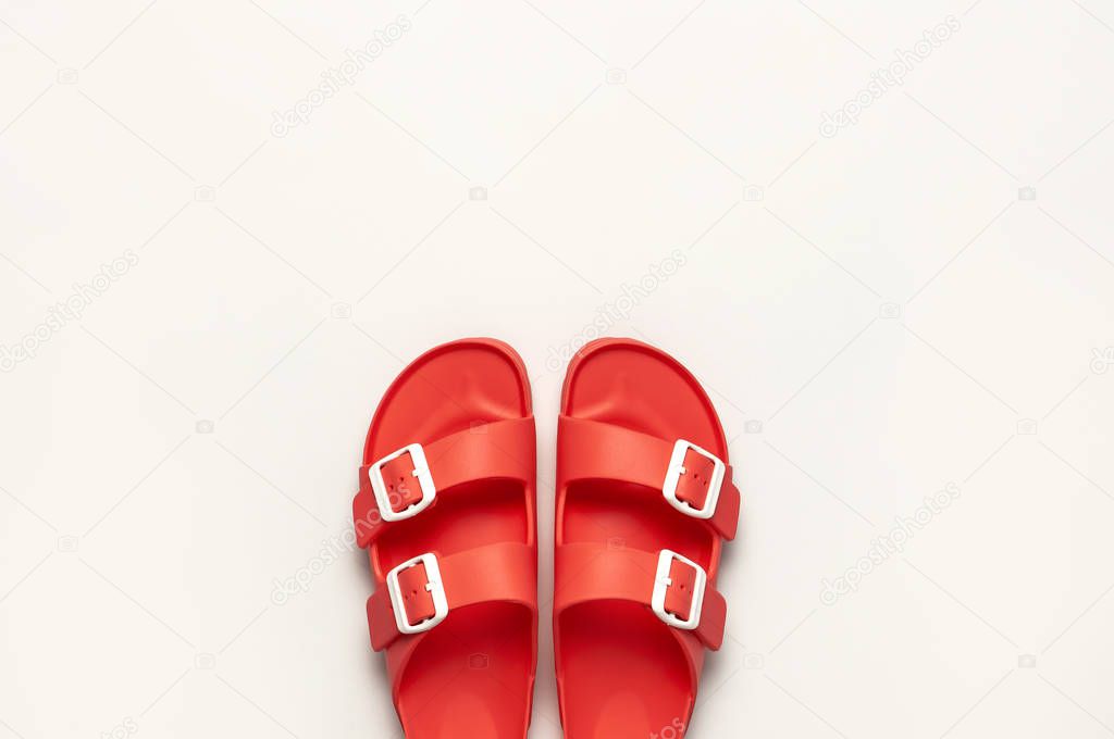 Fashionable beach coral birkenstock on white background. Flat lay, top view, copy space. Creative beach concept, stylish summer shoes, vacation, travel. Coral color. Summer background