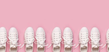 Pembe arka planda beyaz kadın moda ayakkabıları. Düz konum, üst görünüm, kopyalama alanı. Kadın ayakkabıları. Şık beyaz ayakkabılar. Moda blogu ya da dergi konsepti. Minimalist ayakkabı arkaplanı, spor ayakkabıları