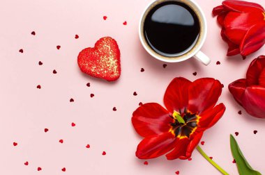 Kırmızı laleler, kırmızı kalp şeklinde hediye kutusu, kahve fincanı, makarna kek, pastel pembe arka plan üst görünümü Düz konfeti yatıyordu. Anneler Günü Sevgililer Günü doğum günü tatil arka plan. Güzel tebrik kartı