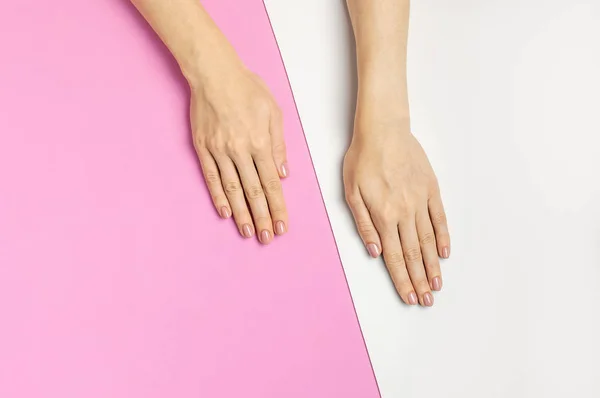 Elegante hermosa manicura suave. Manos de mujer joven sobre fondo rosa vista superior plana laico espacio de copia. Uñas naturales, gel esmalte, cuidado personal, belleza y moda. Cuidado de uñas, Anuncio de salón de belleza — Foto de Stock