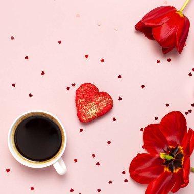 Kırmızı laleler, kırmızı kalp şeklinde hediye kutusu, kahve fincanı, makarna kek, pastel pembe arka plan üst görünümü Düz konfeti yatıyordu. Anneler Günü Sevgililer Günü doğum günü tatil arka plan. Güzel tebrik kartı