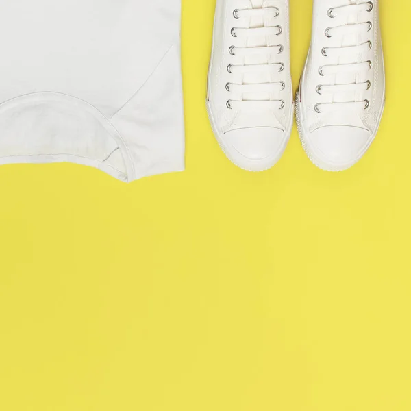 Λευκά γυναικεία παπούτσια μόδας, λευκό μπλουζάκι σε κίτρινο πορτοκαλί φόντο. Επίπεδη όψη αντίγραφο χώρου αντιγραφής. Γυναικεία παπούτσια. Κομψά λευκά αθλητικά παπούτσια. Μόδα blog ή περιοδικό ιδέα. Φόντο παπουτσιών, Αθλητισμός — Φωτογραφία Αρχείου