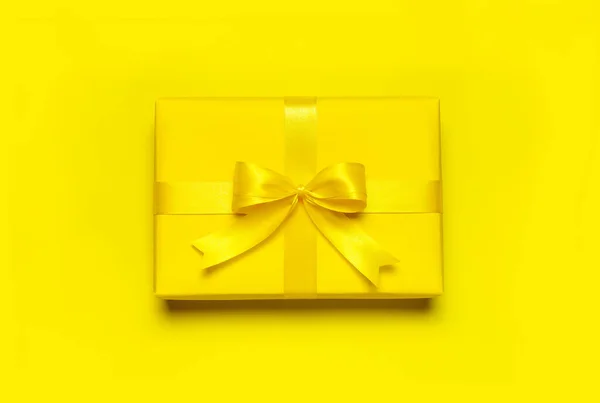 Jasně žlutá dárková dárková krabice s stuhou a lukem na žlutém pozadí horní pohled kopírovat prostor. Byt ležel prázdninové pozadí. Dárek k narozeninám, 8. března, Den matek, Valentýn. Gratuluji — Stock fotografie
