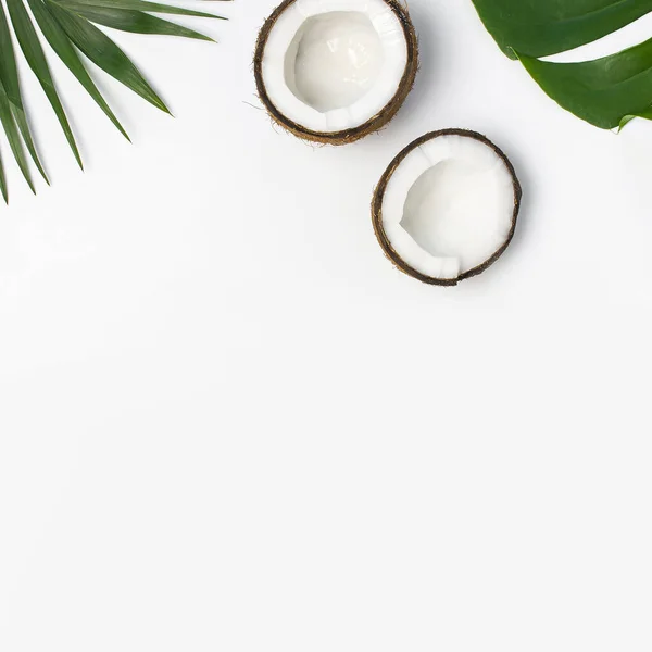 Tropical leaves and fresh coconut on light gray background top view copy space. Summer Flat lay background. Healthy cooking. Creative healthy food concept, half of coconut, nature — Stock Photo, Image