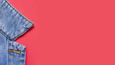 Pembe arka plandaki mavi kot ceketin düz düz fotokopi alanında duruyor. Denim, şık ceket, kadın ya da erkek kıyafetleri, moda geçmişi. Denim dokusu