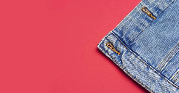 Close-up Niebieska kurtka dżinsowa na różowym tle widok z góry płaski leżał przestrzeń kopii. Jeansy, modna kurtka, odzież damska lub męska, tło mody. Tekstura jeansowa — Zdjęcie stockowe