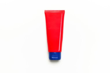 Beyaz arka planda kırmızı, temiz, boş bir krem tüpü ya da eller, yüz ve vücut için jöle. Düz görünüm kopyalama alanı yatıyordu. Kozmetik krem şişelerinin maketi. Tasarım ve logo uygulaması için şablon