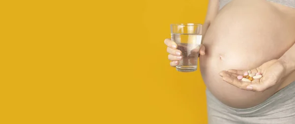 Schöne Junge Schwangere Frau Hält Vitaminpillen Und Ein Glas Wasser — Stockfoto