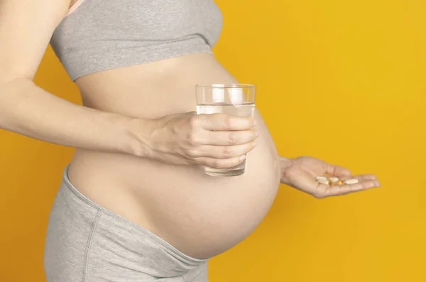 Schöne Junge Schwangere Frau Hält Vitaminpillen Und Ein Glas Wasser — Stockfoto