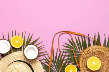 Yaz moda yatağı. Yuvarlak moda rattan çanta, tropikal palmiye yaprakları, hasır şapka, hindistan cevizi, pembe arka planda turuncu. Üst görünüm, boşluğu kopyala. Moda bambu torbası. Yaratıcı arka plan, tatil kavramı.