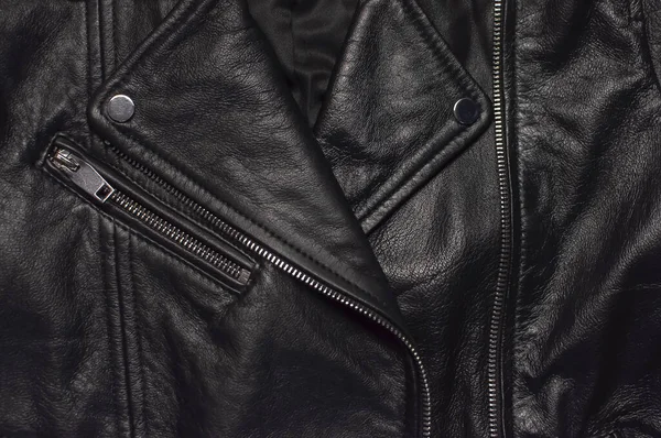 Siyah kadınların deri ceketlerinin üst görüntüsünü kapat. Modayı takip eden modern kadın kıyafetleri. Antika motorcu ceketi. Siyah hakiki deri dokusu.