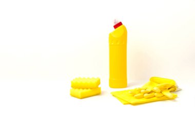 Ev temizliği konsepti. Ev kimyasalları, dezenfektan, çamaşır suyu, antibakteriyel jel, kumaş yumuşatıcı, lastik eldiven, sünger, paçavra, arka planda bulaşık makinesi tabletleri düz zemin temizleme aksesuarları.