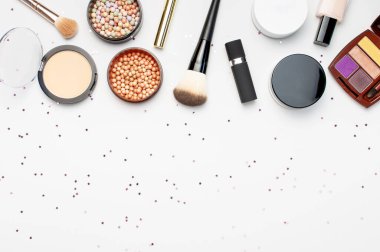 Dekoratif kozmetik maskara tozu ruj göz farı allık makyaj fırçası seti, ışık arka plan üst görünümü nde yıldız konfeti tatil şeritler Düz yatıyordu. Güzellik blogger kavramı. Moda arka plan Makyaj.