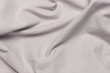 Gri buruşmuş doğal pamuk kumaş üst görünümü. Doğal keten arka plan. Eko tekstil. Beyaz kumaş dokusu. Kumaş arkaplan.