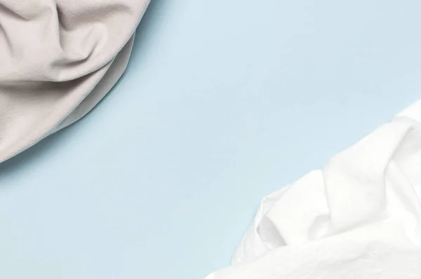 白色和灰色皱皱的天然棉织物在精致的蓝色背景 顶部的视野平坦 与复制空间 天然亚麻布背景 生态纺织品 白色面料质地 面料背景 — 图库照片