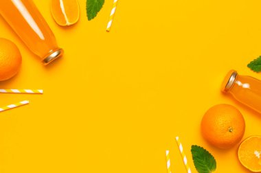 Portakal suyu, taze tatlı portakallar, nane yaprakları ve sarı arka planda küvet içen cam şişeler. Sağlıklı yiyecek, sağlıklı içecek, C vitamini yaratıcı yaz konsepti. Düz görünüm kopyalama alanı.