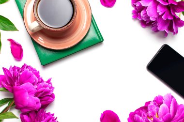 Güzel çiçek şakayıkları, bir fincan kahve, yeşil defter, telefon, beyaz arka plan manzaralı kalem fotokopi alanı. Kadın masaüstü, planlama, sabah kahvesi..