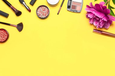 Profesyonel makyaj fırçaları, pudra, göz farı, allık, sarı arka planda ruj kremi düz görünüm fotokopi alanı yatıyordu. Güzellik ürünleri kadın aksesuarları. Farklı fırçalar Kozmetik makyaj seti.