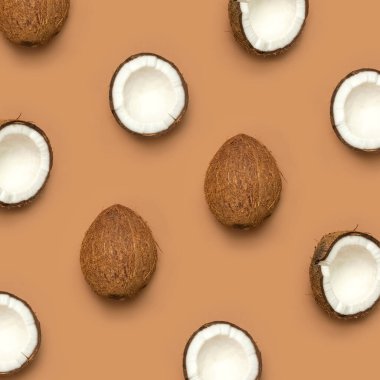 Hindistan cevizi desenli yaratıcı bir düzen. Kahverengi arka planda tam ve yarım hindistan cevizi. En az düz konum biçimi, en üst görünüm kopyalama alanı. Yemek konsepti. Tropik egzotik meyve, altın yaz arkaplanı. Pankart.