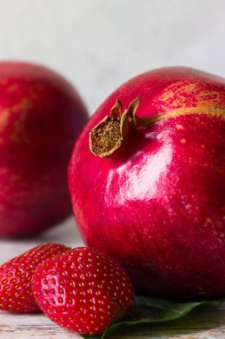 Nar ve hafif bir arka plan üzerinde çilek