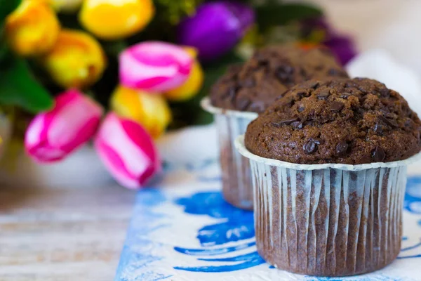 Muffins de chocolate no dia de uma mãe no fundo das flores — Fotografia de Stock