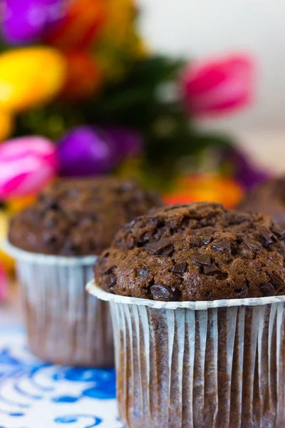 Muffins de chocolate no fundo de tulipas — Fotografia de Stock