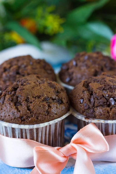 Quatro muffins de chocolate com fita rosa — Fotografia de Stock