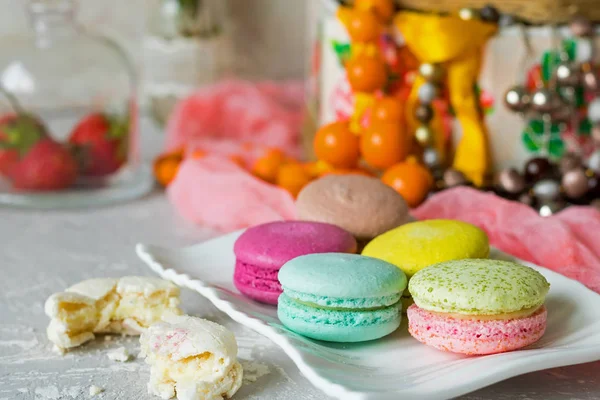 Différents macarons sur une assiette blanche sur un fond clair — Photo