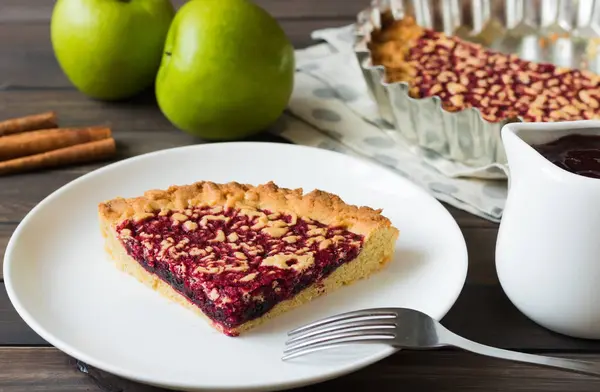 Пирог с яблоком и ягодным вареньем на темном деревянном фоне — стоковое фото