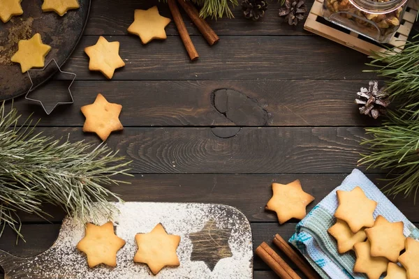 Kerstkoekjes in de vorm van sterren op een donkere houten achtergrond. Plaats voor tekst. — Stockfoto