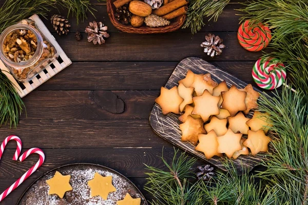 Koyu ahşap arka plan üzerinde yıldız şeklinde Noel kurabiyeleri. Metin için yer.