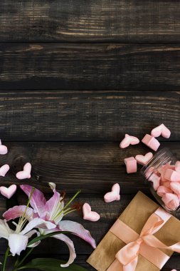 Marshmallow hearts, love letter and flowers on an old wooden background clipart