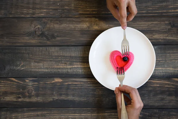 Bir kalp şeklinde pasta yemeye Çift