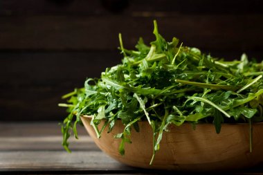 Rustik koyu arka plan üzerinde Su damlacıkları ile taze rucola