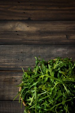 Rustik koyu arka plan üzerinde Su damlacıkları ile taze rucola