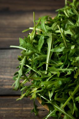 Rustik koyu arka plan üzerinde Su damlacıkları ile taze rucola