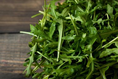 Rustik koyu arka plan üzerinde Su damlacıkları ile taze rucola